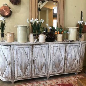 bleached credenza with olive jars and mirror sitting on top